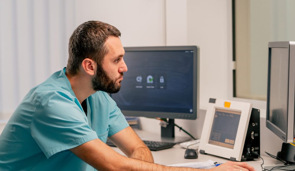 A clinician reviewing records at a hospital workstation